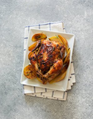 Elma ve armut gri taş zemin üzerine beyaz tabakta tavuk kızarmış. Düz yatıyordu. 