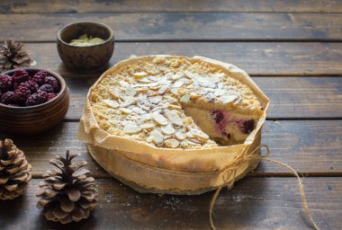 Doğal ahşap arka planda rendelenmiş ricotta, böğürtlen ve badem gevreği.