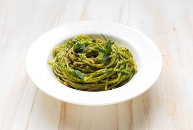 Fesleğenli İtalyan makarnası ve beyaz tabakta ıspanak pesto.