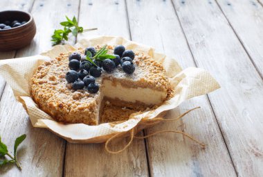 Doğal ahşap zemin üzerinde ricotta ile rendelenmiş kırsal turta. Yakın plan.