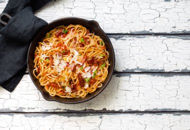 Kızarmış sosisli İtalyan makarnası, domates sosu ve tavada parmesan peyniri.
