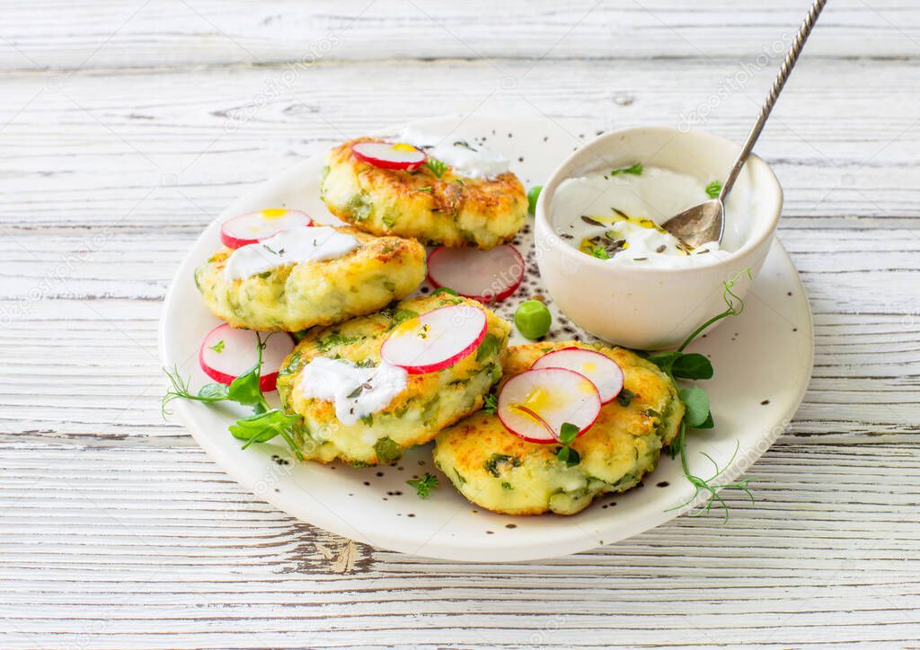 Cottage cheese pancakes with spinach served on white plate close up 