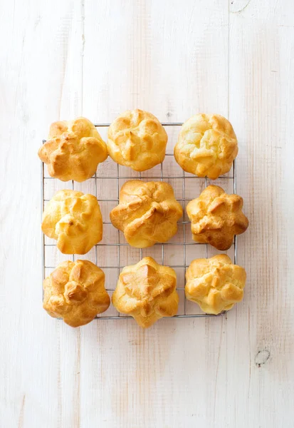 Bakade Profiteroles Vit Trä Bakgrund Ett Platt Ligg Kopiera Utrymme — Stockfoto