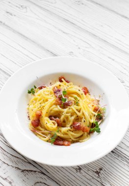 Beyaz tabakta kızarmış domuz pastırması ve parmesan peynirli klasik makarna. Boşluğu kopyala