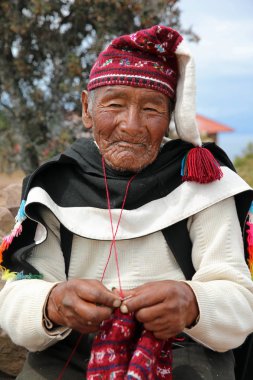 : Puno, Peru 24 Ekim 2018: Geleneksel kıyafeti örgü iken Taquile ada için belirli tanımlanamayan adam. Titicaca Gölü, 45 km açıkta Puno şehir Taquile Adası üzerindedir. Peru