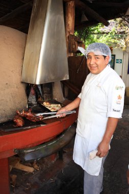 Cusco, Peru - 22 Ekim 2018: Cusco'daki Restaurant Pachapacha'da kimliği belirsiz adam. Peru'daki geleneksel Yemek'i Kobay'ı Kızdırıyor