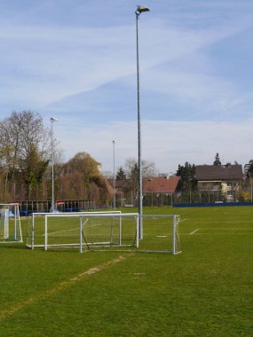Soccer field with a tall light pole in the background. The field is empty and the grass is green