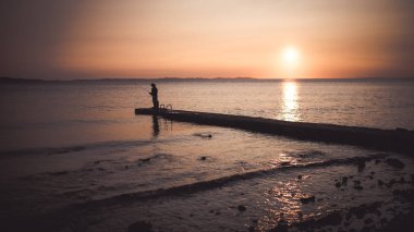 İki fishermans günbatımı sırasında maliyetle. Hırvatistan kıyı şeridi.