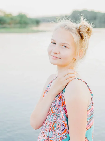 sarışın kız yaz aylarında gün batımında nehir boyunca yürüyüş