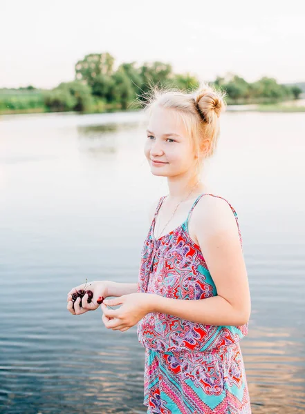 sarışın kız bir kiraz su birikintisi yakın vardır.