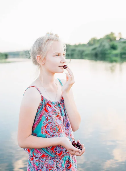 sarışın kız bir kiraz su birikintisi yakın vardır.