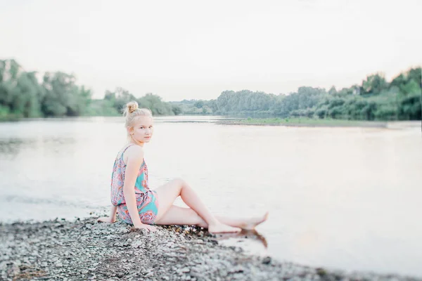 sarışın kız yaz aylarında gün batımında nehir boyunca yürüyüş