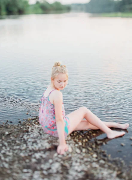 sarışın kız yaz aylarında gün batımında nehir boyunca yürüyüş