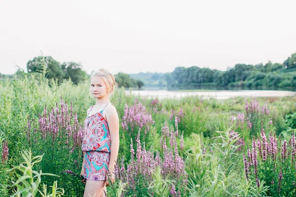 sarışın kız yaz aylarında gün batımında nehir boyunca yürüyüş