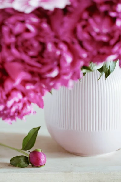 Koyu pembe peonies bir vazo içinde. Natürmort. Kahverengi zemin