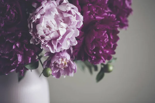 Koyu pembe peonies bir vazo içinde. Natürmort. Kahverengi zemin