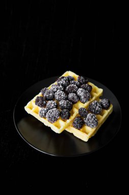 Siyah bir zemin üzerine donmuş böğürtlen ile Belçika gofret