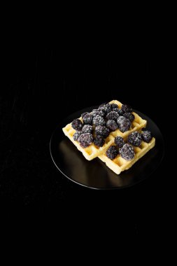 Siyah bir zemin üzerine donmuş böğürtlen ile Belçika gofret