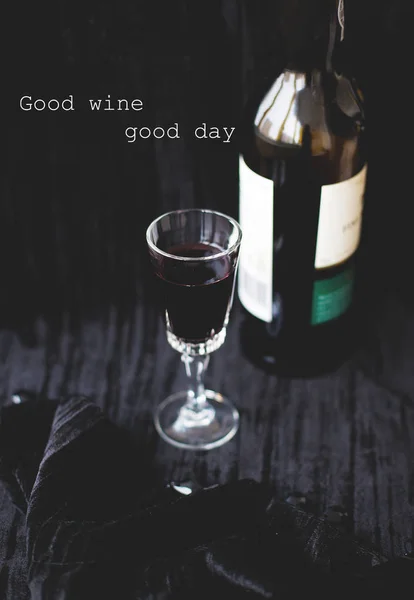 glass of wine on a black background with the words good wine, good day.