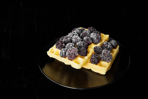 Belgische Waffeln mit gefrorenen Brombeeren auf schwarzem Hintergrund, Nahaufnahme — Stockfoto