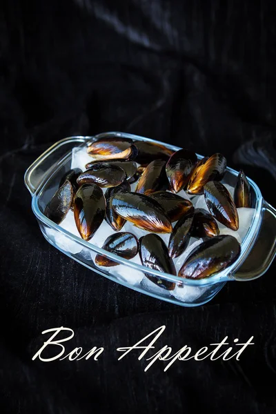 Very tasty and fresh mussels on ice cubes-the inscription of a Bon Appetit. — Stock Photo, Image