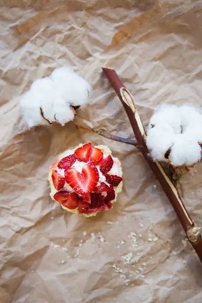 Bellissimo muffin con fragole fresche giace su carta artigianale, primo piano — Foto Stock