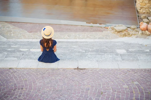 Dívka sedí zády v amfiteátru. Bulharsko, Nessebar — Stock fotografie