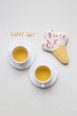 two cups of coffee on a table with cookies clipart