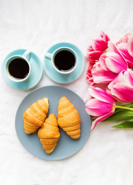 Two cups of coffee, croissants and a bouquet of pink tulips, beautiful morning — Stock Photo, Image