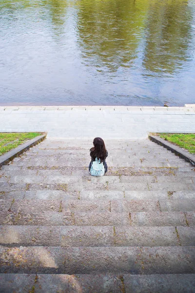 Bella ragazza si siede e guarda il fiume Vilnius - Lituania — Foto Stock