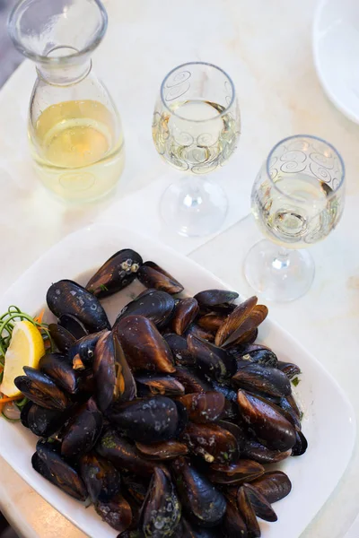 Vino blanco y mejillones en un caparazón en un café sobre la mesa —  Fotos de Stock