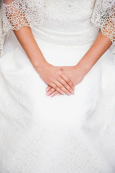 Mano de novia en vestido de novia con una bonita manicura — Foto de Stock