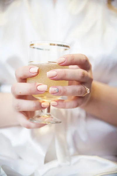 Bruiden hand met trouwring houden van een glas champagne en bubbels — Stockfoto