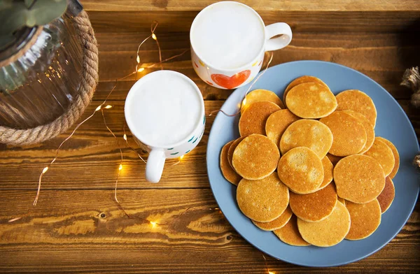 Tasty punkakes and two cups of coffee stand on a wooden tray — Stock Photo, Image