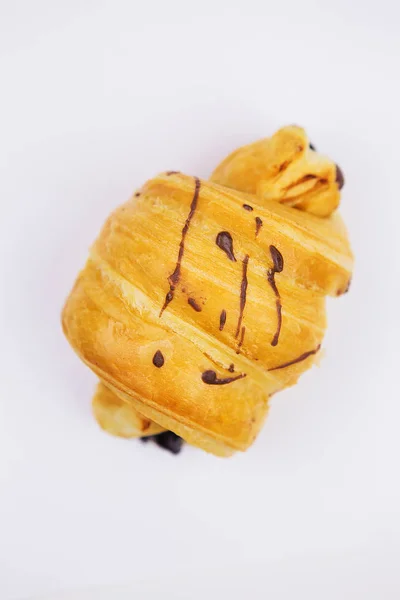 Färsk croissant med choklad-top dekorationer, isolering på vit bakgrund — Stockfoto
