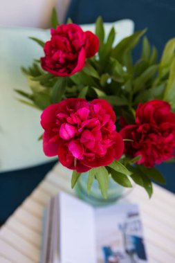 güzel peonies yalanlar üzerine beyaz bir tablo bir mavi çanta ve kitap birlikte büyük bir buket