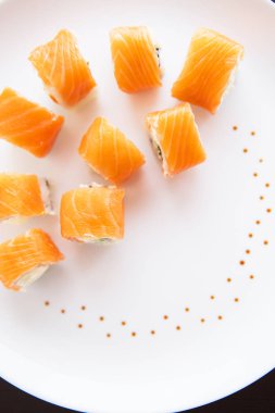 Suşi rulo somon, philadelphia beyaz tabakta üstten görünüm. Yakın çekim. Plaka dekore edilmiş