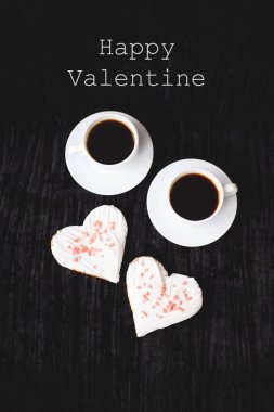 İki bardak kahve ve bisküvi kalp yazıt Happy Valentine şeklinde.