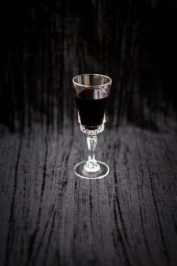 Siyah kadife arka planda bir kadeh kırmızı şarap, yakın plan..