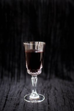 Siyah kadife arka planda bir kadeh kırmızı şarap, yakın plan..