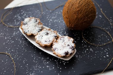 Hindistan cevizi kek çikolata bir siyah arka plan ve bütün Hindistan cevizi ile