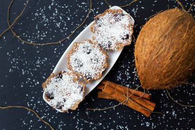 Hindistan cevizi kek Çikolata ve tarçın bir siyah arka plan ve bütün Hindistan cevizi ile