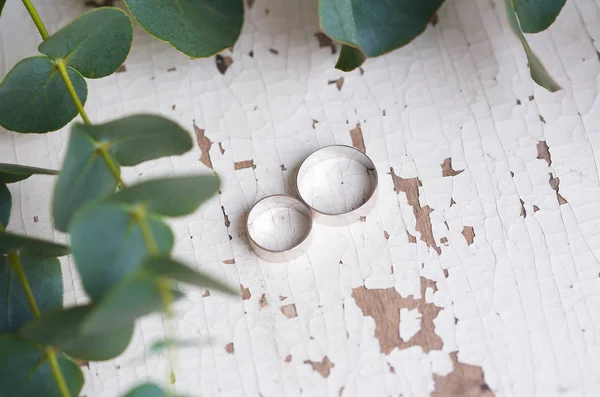 Dos Anillos Boda Una Mesa Blanca Con Viejas Ramas Eucalipto — Foto de Stock