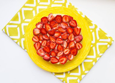 Sarı bir peçeteye güzel ve lezzetli çilekli kek standları.