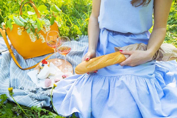 Dívka sedí na pestrobarevném pikniku s přírodou-vínem, jahodem, sýrem, koláčem — Stock fotografie