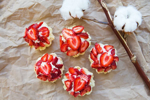 Sehr leckere Muffins mit frischen Erdbeeren liegen auf Kraftpapier — Stockfoto