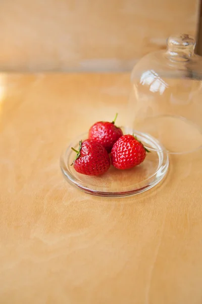 Stroberi dalam mangkuk kaca dengan latar belakang kayu — Stok Foto