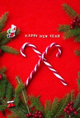 Noel ağacı ve Happy New Year kelimelerle kırmızı bir arka plan üzerinde şeker