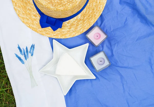 Hat, brie cheese in a plate on blue tablecloth — Stock Photo, Image