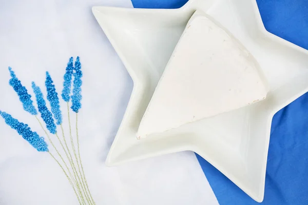 Hut, Brie-Käse in einem Teller auf blauer Tischdecke — Stockfoto